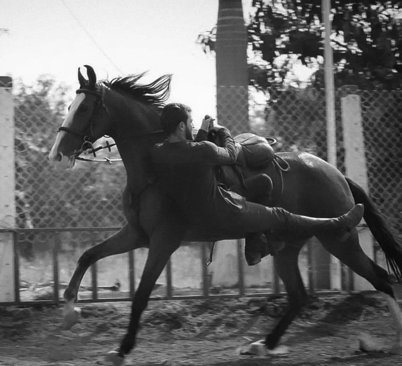 Stunt performer practicing a vaulting move on a horse during training for film stunts